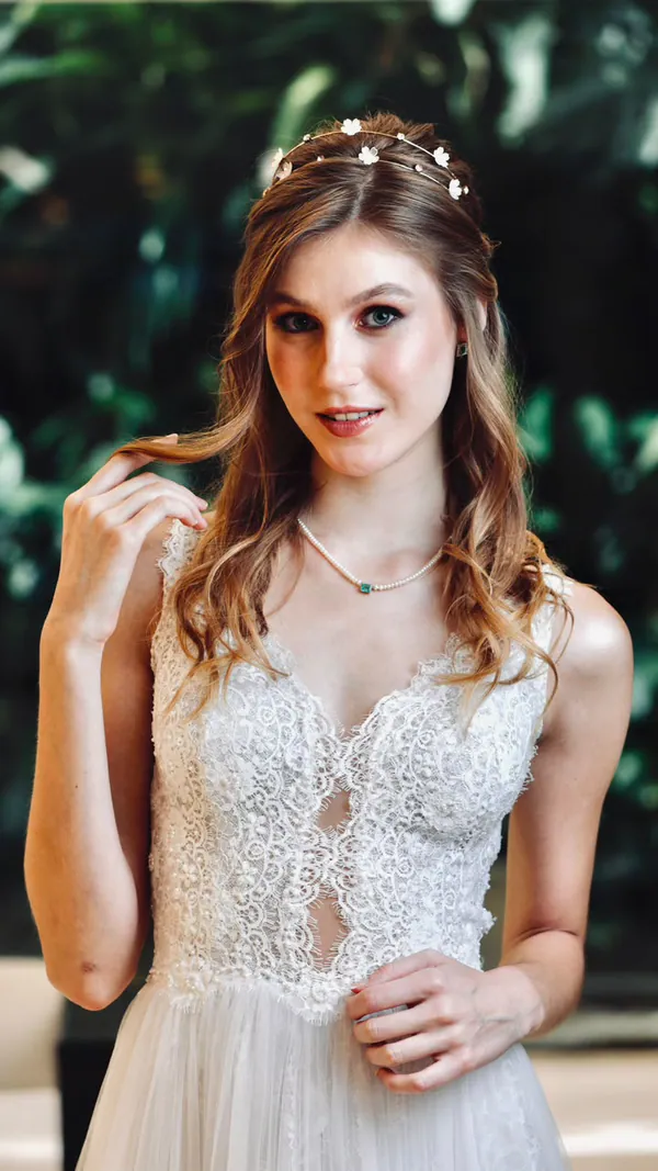 Editorial de noiva com tiara de flores e vestido de renda, com folhagem ao fundo
